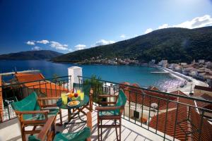 un balcone con tavolo, sedie e un secchio d'acqua. di Boulevard Aetos Suites a Ayia Evfimia