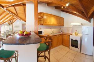 a kitchen with a island with a bowl of fruit on it at Boulevard Aetos Suites in Ayia Evfimia