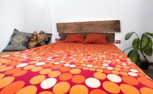 NazaretにあるApartamento Estudio Lyraのベッド(オレンジと白の水玉ブランケット付)