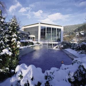 um grande edifício com piscina na neve em Hotel Traube em Bad Wildbad