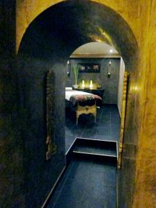 シャトネ・マラブリーにあるLa Demeure des Tilleulsのベッドとテーブル付きの暗い部屋