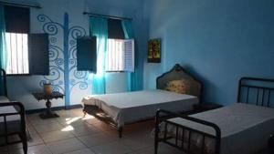 a bedroom with two beds and blue walls at Casarão do Pontal in Coruripe