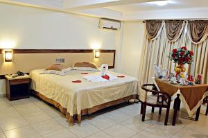 a hotel room with a bed and a table at Praia Sol Hotel in Santa Terezinha de Itaipu