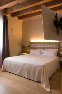 a bedroom with a large white bed in a room at Hotel Sesmones in Lodi