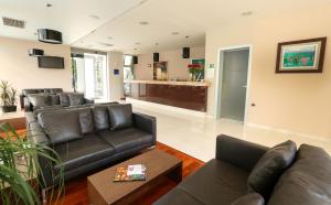 a living room with a leather couch and a table at Hotel Indijan in Orebić