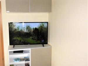 a flat screen tv sitting on a stand in a room at Ferienwohnung Krabbentaucher 2 in Neßmersiel