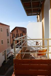 a chair sitting on the balcony of a building at Hôtel Méditerranée in Calvi