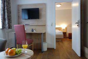 um quarto de hotel com uma mesa com um copo de sumo de laranja em Landgasthof zum Adler em Lippertsreute