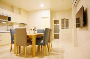 uma sala de jantar com mesa e cadeiras de madeira em Zhuji Hostel em Donggang