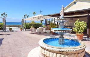 a fountain on a patio with the ocean in the background at Hotel Costa d'Oro in Santa Maria di Castellabate