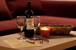 a table with two glasses and a bottle of wine and a candle at Ferienzimmer Am Brauhausgraben in Lübbenau