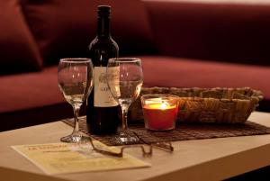 einen Tisch mit zwei Gläsern, einer Flasche Wein und einer Kerze in der Unterkunft Ferienzimmer Am Brauhausgraben in Lübbenau