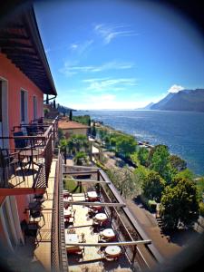 een balkon van een gebouw met uitzicht op het water bij Hotel Villa Carmen in Malcesine