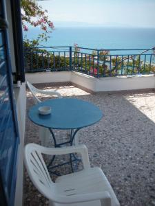 a table and chairs on a balcony with the ocean at Hotel Hariklia in Agia Galini