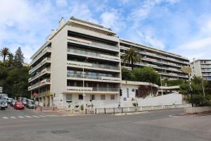 ein großes weißes Gebäude an der Ecke einer Straße in der Unterkunft Résidence Le Président - Forville in Cannes
