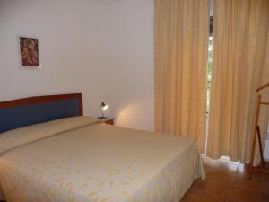 ein Schlafzimmer mit einem Bett und einem Fenster mit Vorhängen in der Unterkunft Villa Les Hameaux Di Santa Giulia in Porto-Vecchio + 29 Fotos