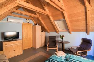 a room with a bed and a tv and a table at Vulcano Vendégház in Kisapáti