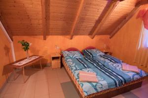 a bedroom with a bed with a table and a table sidx sidx sidx at Vulcano Vendégház in Kisapáti