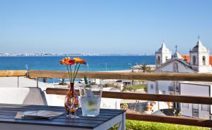 a table with two glasses and a vase with flowers at The Salty Lodge in Lagos