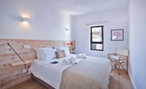 a bedroom with a bed with white sheets and a desk at The Salty Lodge in Lagos