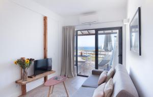 a living room with a couch and a tv and a balcony at The Salty Lodge in Lagos