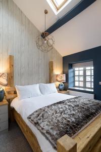 1 dormitorio con 1 cama grande y pared de madera en The Wheatsheaf Inn en Onneley