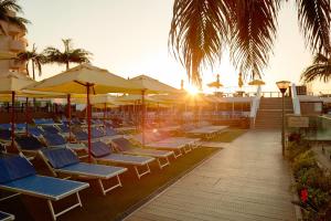 un gruppo di sedie a sdraio e ombrelloni presso un resort di First Group La Montagne a Ballito