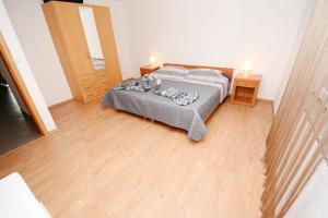 a bedroom with a bed and a wooden floor at Apartments Katarina in Veli Rat