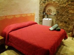 ラ・スペツィアにあるApartment Camere Cinque Terre Andreaの石壁のベッドルーム1室(赤いベッド1台付)
