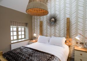 a bedroom with a bed and a wall with stripes at The Wheatsheaf Inn in Onneley