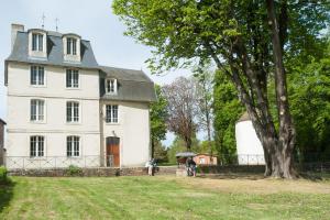 a large white house with people standing in front of it at Gîtes de La Futaie in Sauzé-Vaussais