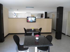 Una habitación con una mesa y sillas y un televisor. en Hotel Piramide Pernambués (Adults Only), en Salvador