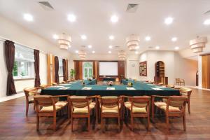 カルパチにあるHotel Vivaldiの大きなテーブルと椅子が備わる大きな会議室を利用できます。