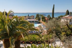 a resort on the beach with a palm tree at Olivi Hotel & Natural Spa in Sirmione