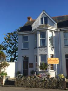 a white house with a sign in front of it at Smarties Surf Lodge in Newquay