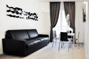 ローマにあるLHP Suite Roma Terminiのリビングルーム(黒い革張りのソファ、テーブル付)