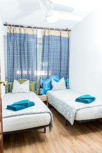 バレンシアにあるModern Apartment Playaの青いカーテンが備わる客室のベッド2台