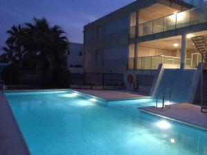 a swimming pool in front of a building at night at Apartamento Nautilus Beach in Carboneras +35 photos