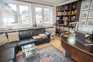 a living room with a leather couch and a table at Apartement mit Dachterrasse - bei Curth klingen - Teilen Sie uns Ihre Ankunfszeit mit in Düsseldorf
