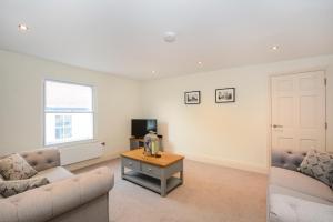 a living room with two couches and a tv at Minster's Keep- Stylish Apartment Near York Minster in York