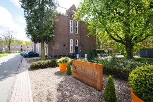 un edificio de ladrillo con un cartel delante en B&B Landgoed De Grote Beek, en Eindhoven