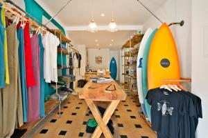 a room with surfboards and a wooden table at The Salty Lodge in Lagos