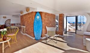 a room with a brick wall with a surfboard on it at The Salty Lodge in Lagos