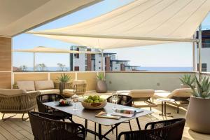 a patio with a table with a bowl of fruit on it at Almar Jesolo Resort & Spa in Lido di Jesolo