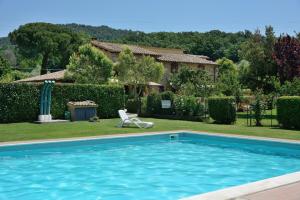 a man sitting in a lawn chair next to a swimming pool at AgriResidence L'Antica Fattoria - sul Lago in Bolsena