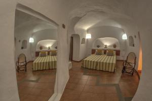 a room with two beds in a room with an archway at Cuevas De Barreto in Firgas