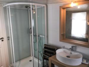 a bathroom with a shower and a sink at Cape East Homestay in Ytre Kiberg +36 photos