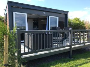 a black modular house with a deck and windows at Higher Moor Farm in Weymouth