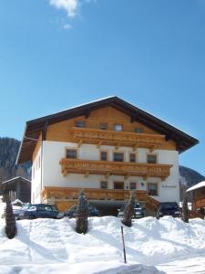 un grand bâtiment avec de la neige devant lui dans l'établissement Gabershof, à Sankt Jakob in Defereggen