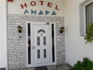 uma porta branca com uma placa que lê Hotel Ahka em Lidra em Korinos